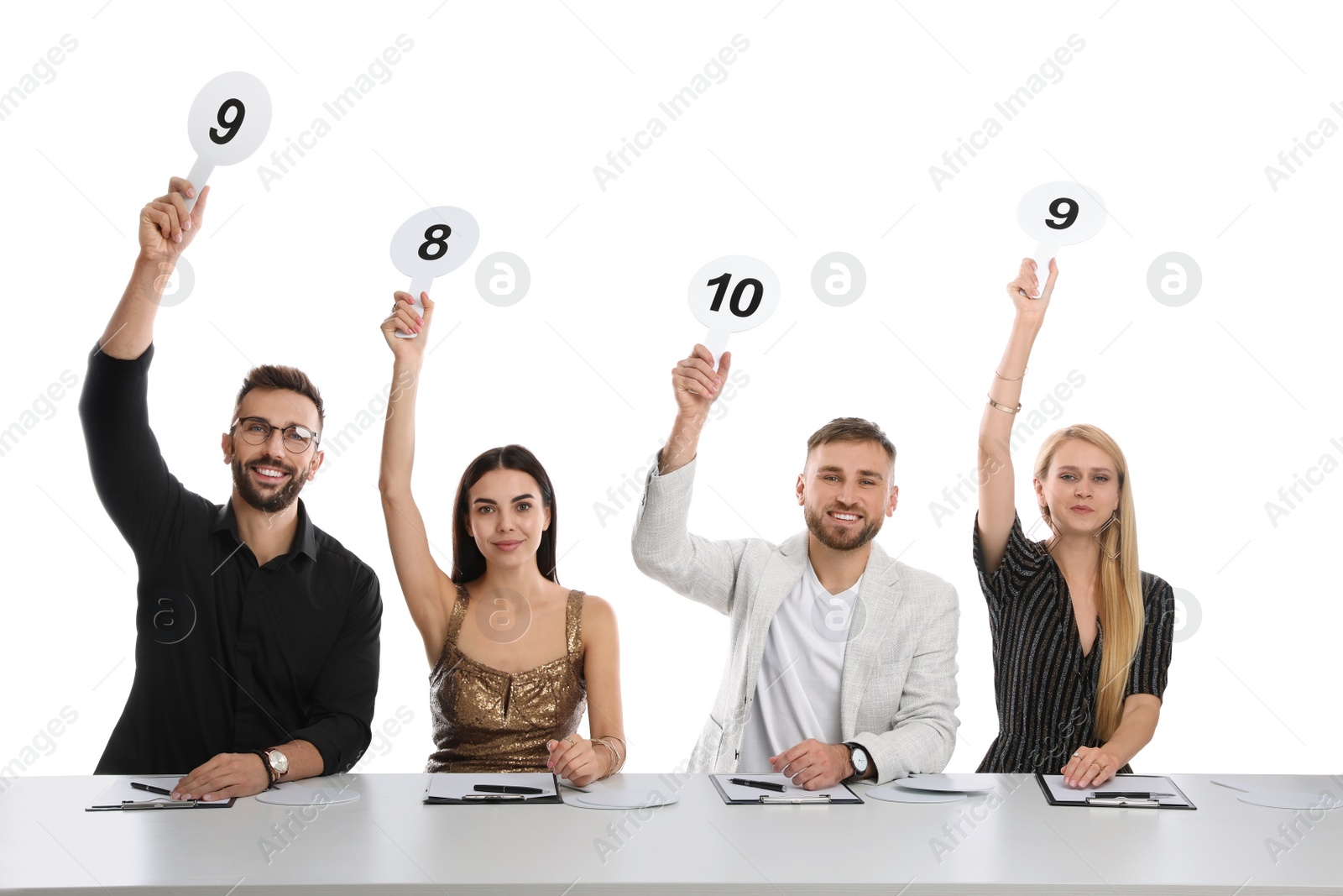 Photo of Panel of judges holding different score signs at table on white background