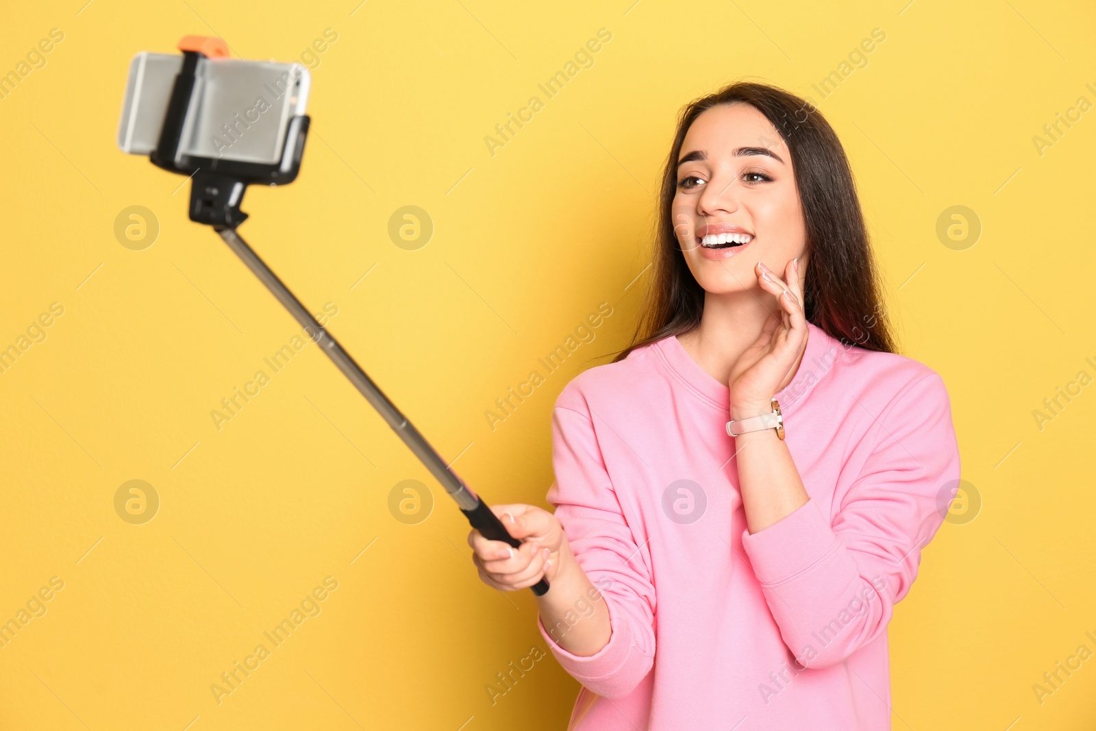 Photo of Young beautiful woman taking selfie against color background