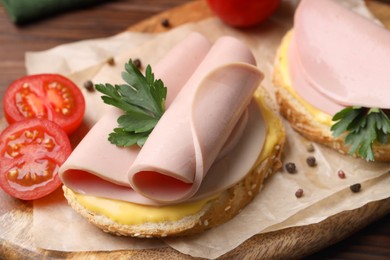 Photo of Delicious sandwiches with boiled sausage, cheese and tomato on table, closeup
