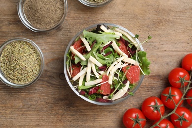 Photo of Delicious carrot salad served on wooden table, flat lay