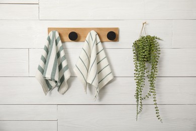 Photo of Different clean kitchen towels hanging on rack