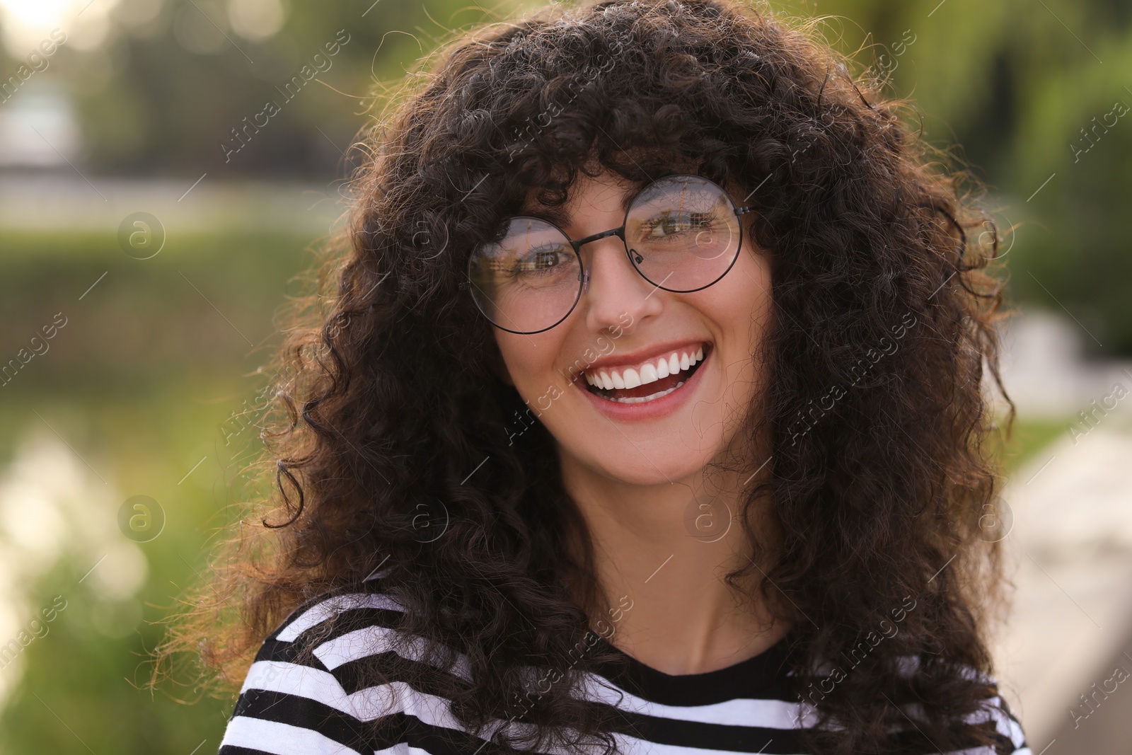 Photo of Portrait of beautiful woman in glasses on blurred background. Attractive lady smiling and looking into camera