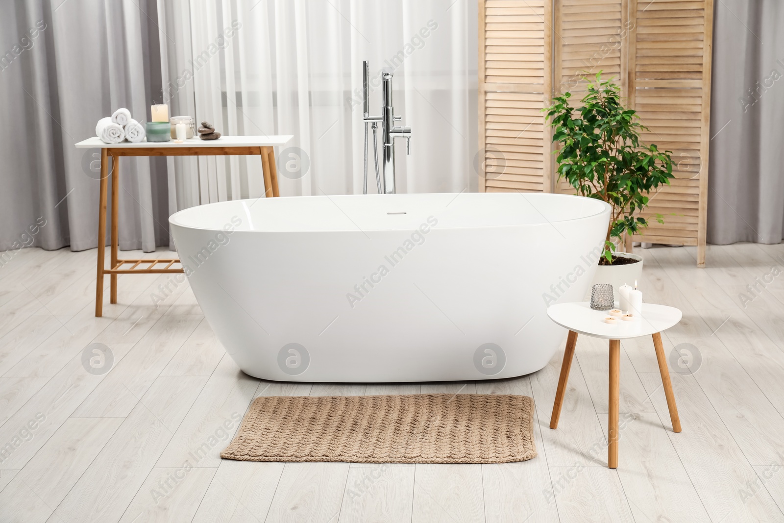 Photo of Ceramic tub, houseplant and spa products in bathroom