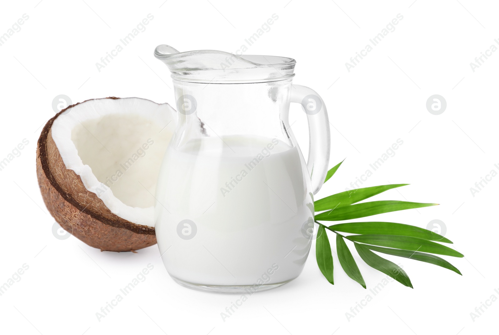 Photo of Glass jug of delicious vegan milk, coconut and leaf on white background