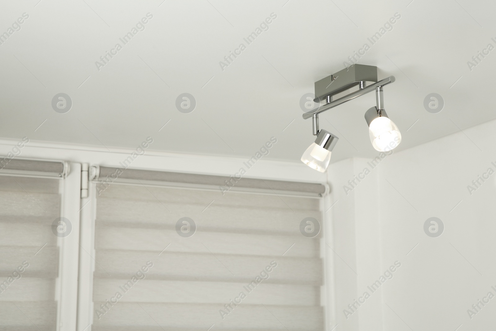 Photo of Stylish light fixture on ceiling indoors, low angle view