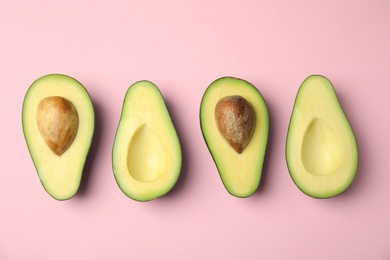 Cut fresh ripe avocados on pink background, flat lay