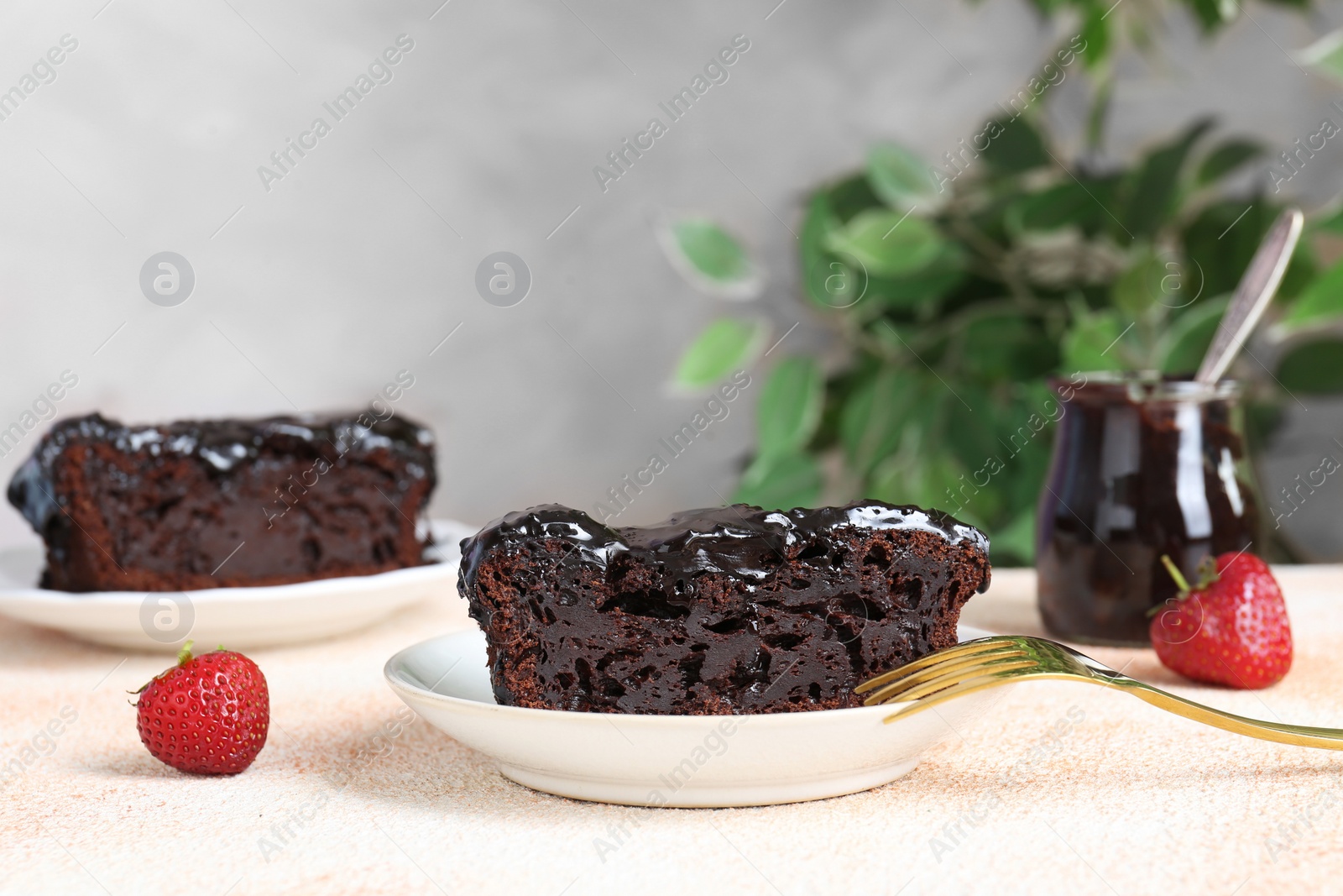 Photo of Piece of chocolate sponge cake on beige textured table