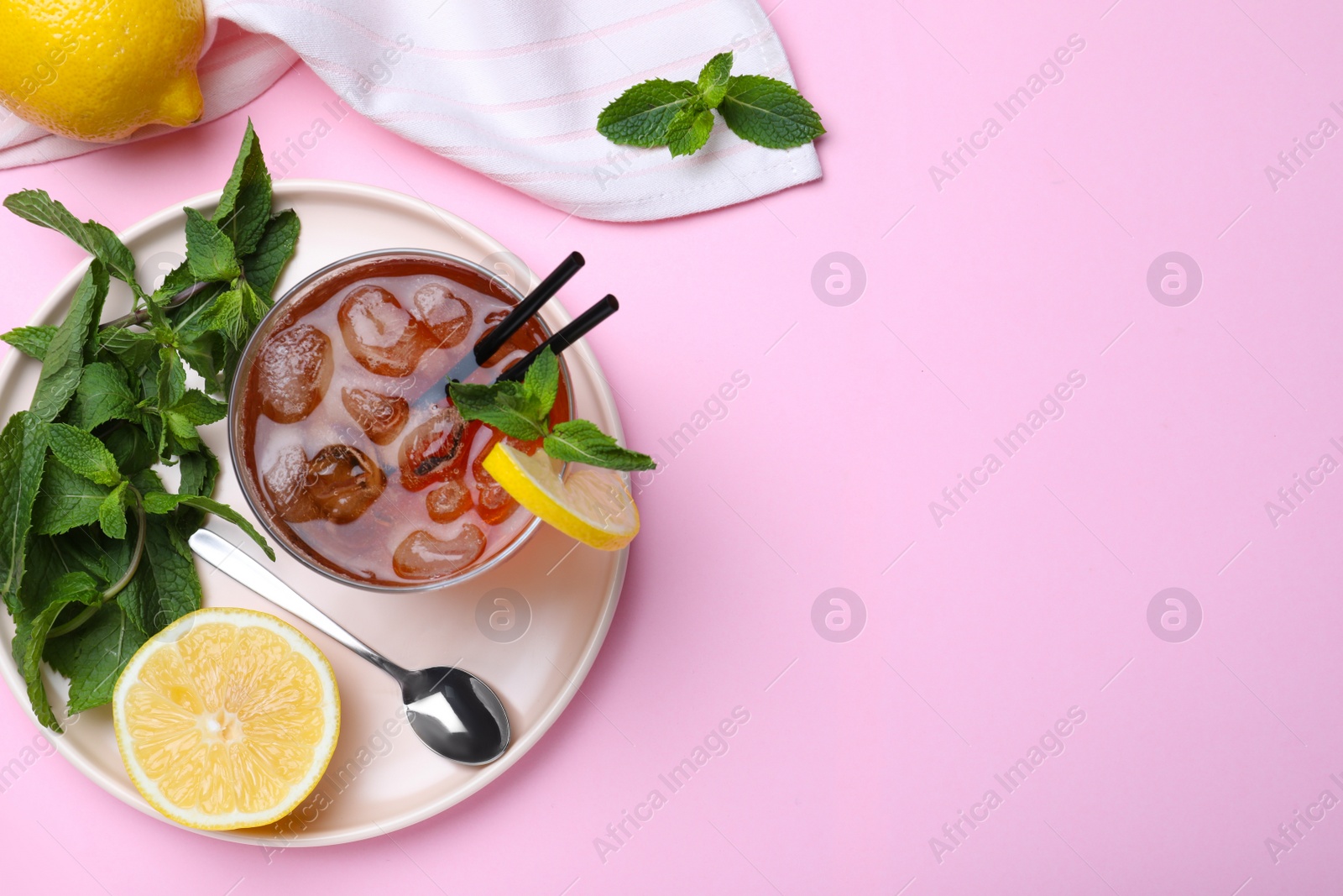 Photo of Delicious iced tea with lemon and mint on pink background, flat lay. Space for text