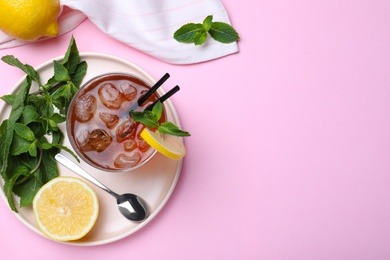 Photo of Delicious iced tea with lemon and mint on pink background, flat lay. Space for text