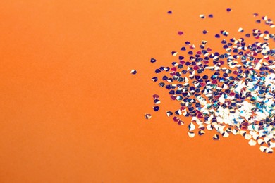 Photo of Shiny bright glitter on coral background. Space for text