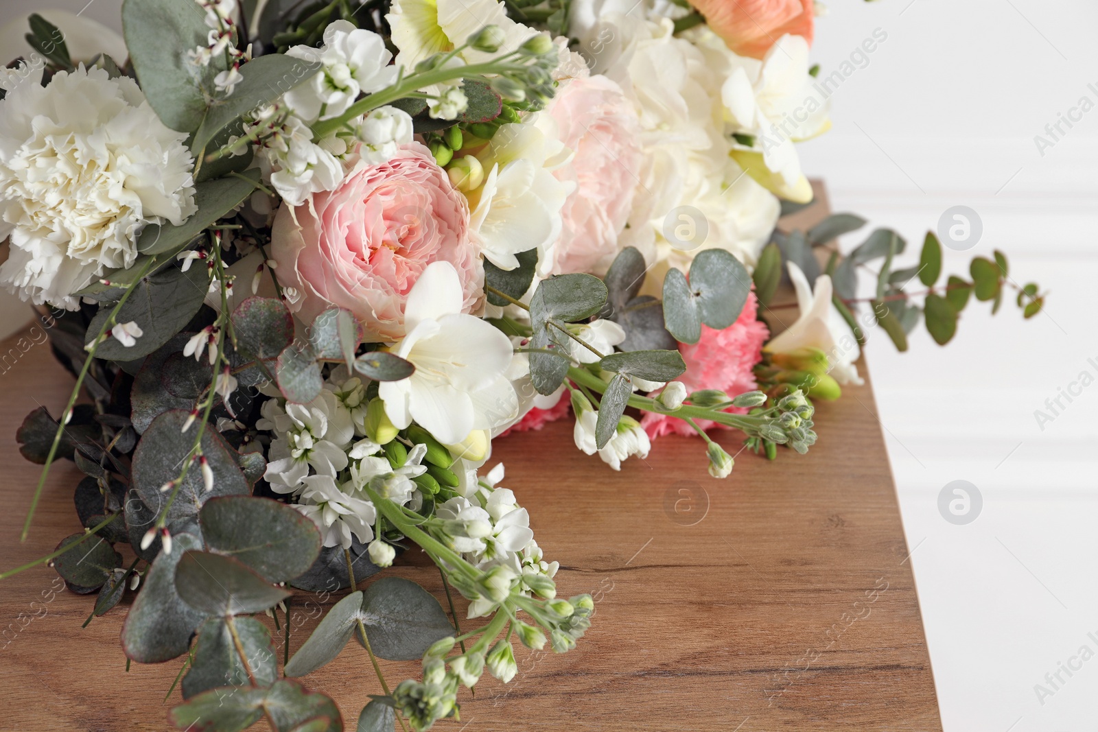 Photo of Bouquet of beautiful flowers on wooden table, closeup