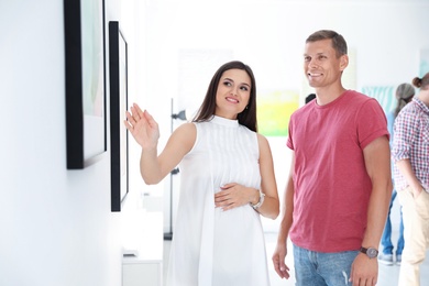 Young couple at exhibition in art gallery