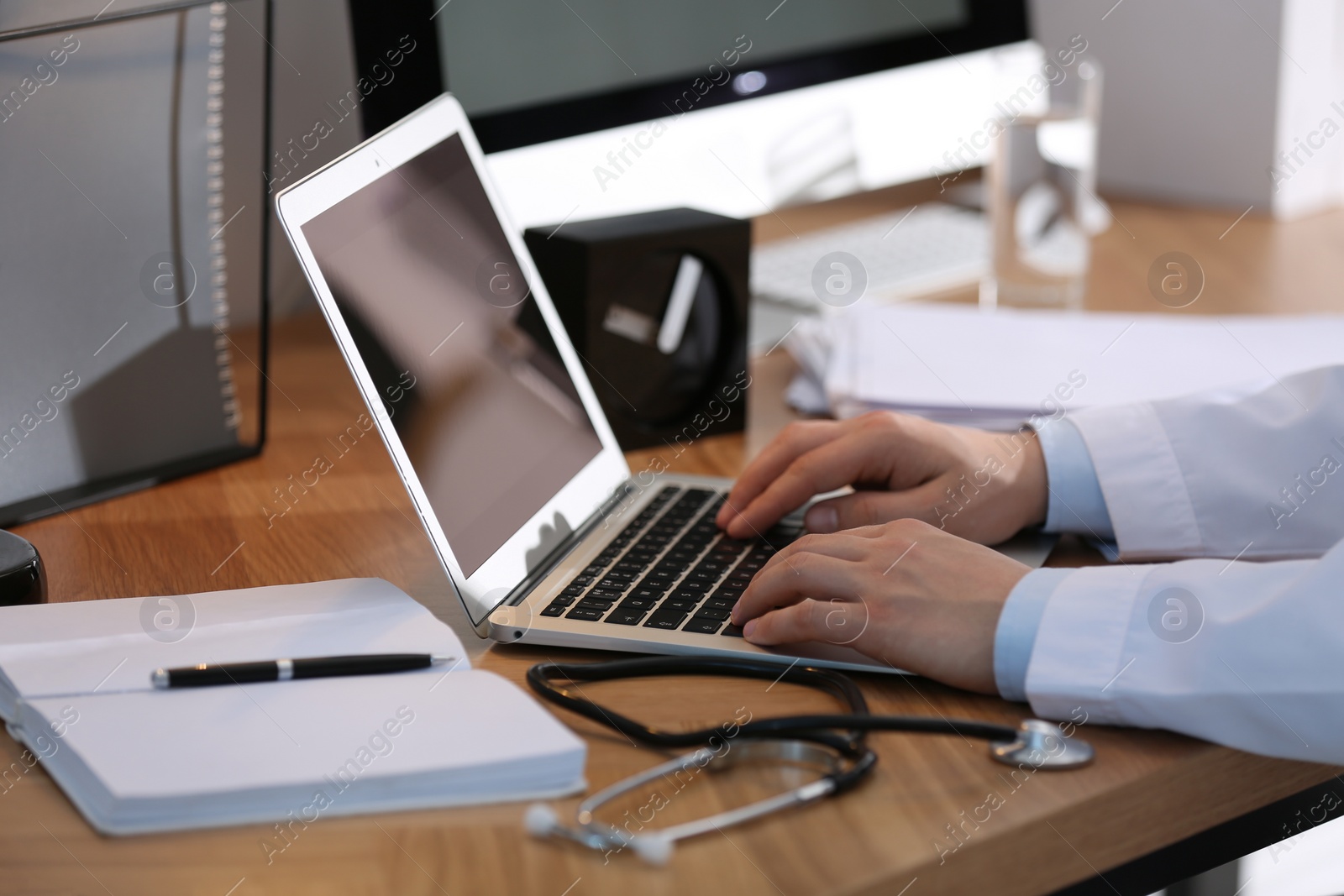 Photo of Professional doctor working on laptop in office, closeup