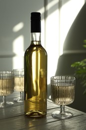 Alcohol drink in glasses and bottle on wooden table indoors