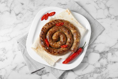 Photo of Delicious homemade sausage with chili pepper and lavash on white marble table, top view