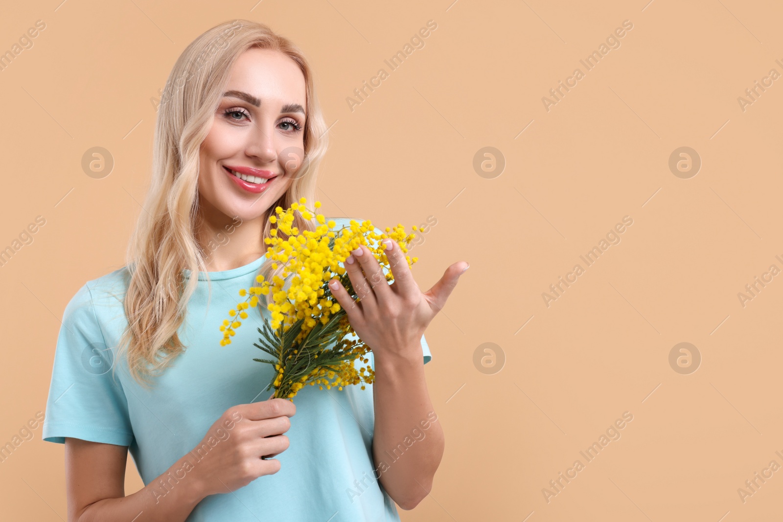 Photo of Happy young woman with beautiful bouquet on beige background. Space for text