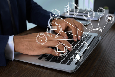 Image of Man using laptop to control smart home, closeup. Automatic systems