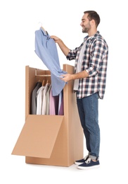 Young man near wardrobe box on white background