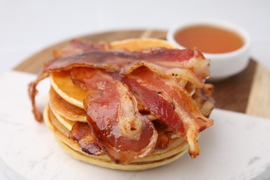 Photo of Delicious pancakes with bacon and honey on white table, closeup