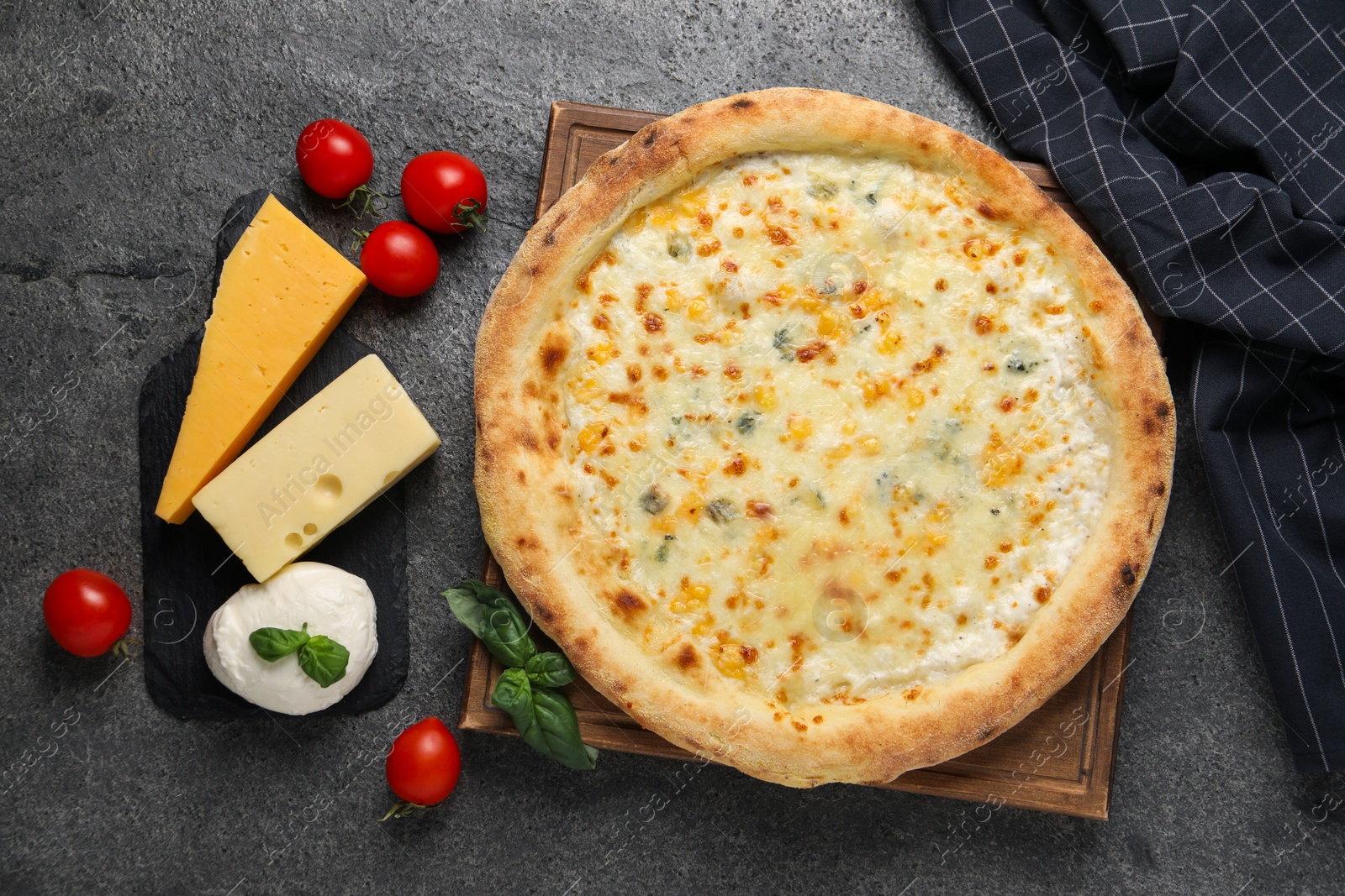 Photo of Delicious cheese pizza and ingredients on dark grey table, flat lay