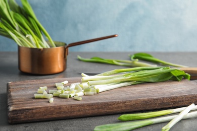 Board with wild garlic or ramson on table. Space for text