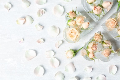 Photo of Heart shaped ice cubes with roses on light background, flat lay. Space for text