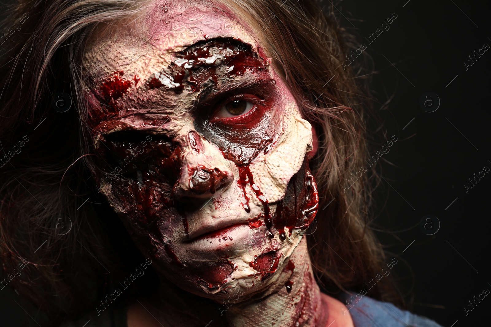 Photo of Scary zombie on dark background, closeup. Halloween monster