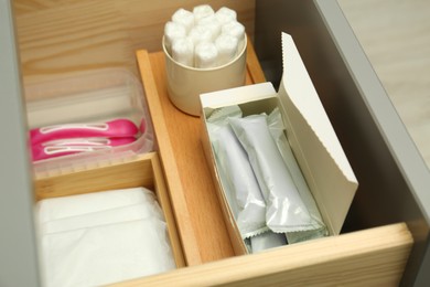 Storage of different feminine hygiene products in drawer, closeup