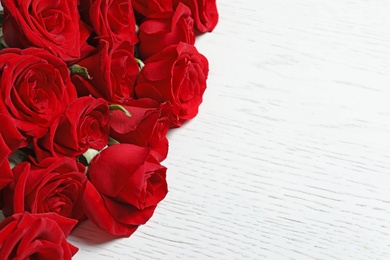 Photo of Beautiful red rose flowers on wooden background