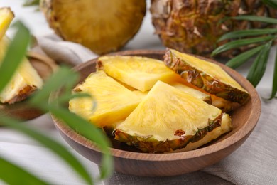 Photo of Pieces of tasty ripe pineapple in bowl on table, closeup