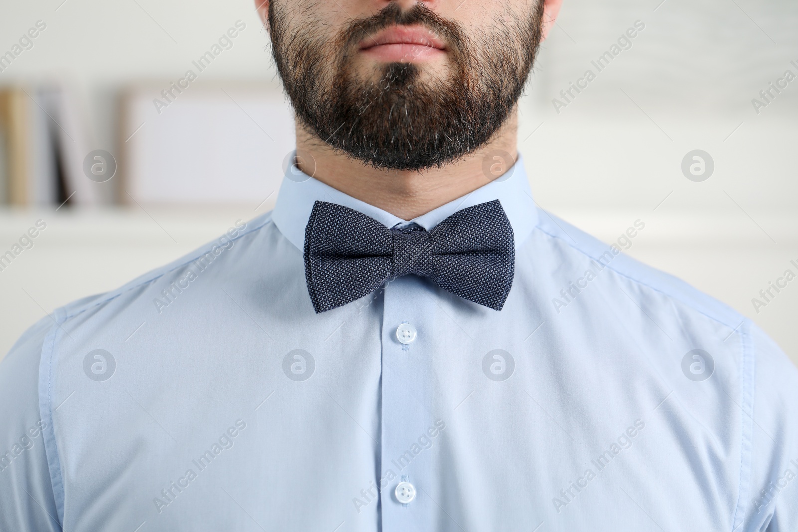 Photo of Man in shirt and bow tie indoors, closeup