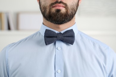 Photo of Man in shirt and bow tie indoors, closeup