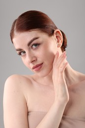 Portrait of beautiful woman on grey background, closeup