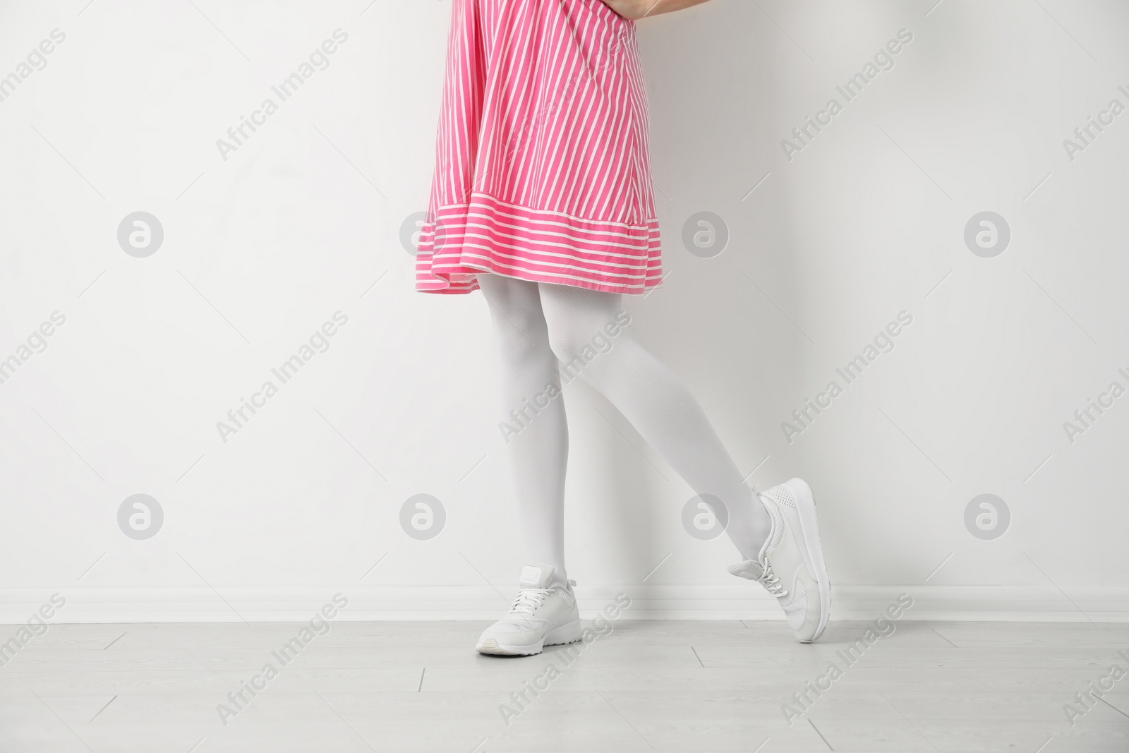 Photo of Woman wearing tights near white wall, closeup