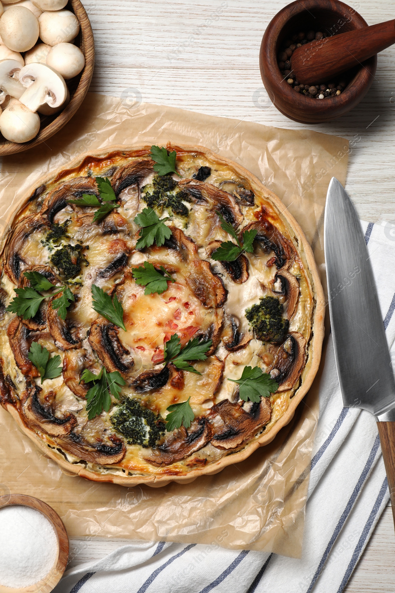 Photo of Delicious quiche with mushrooms and ingredients on white wooden table, flat lay