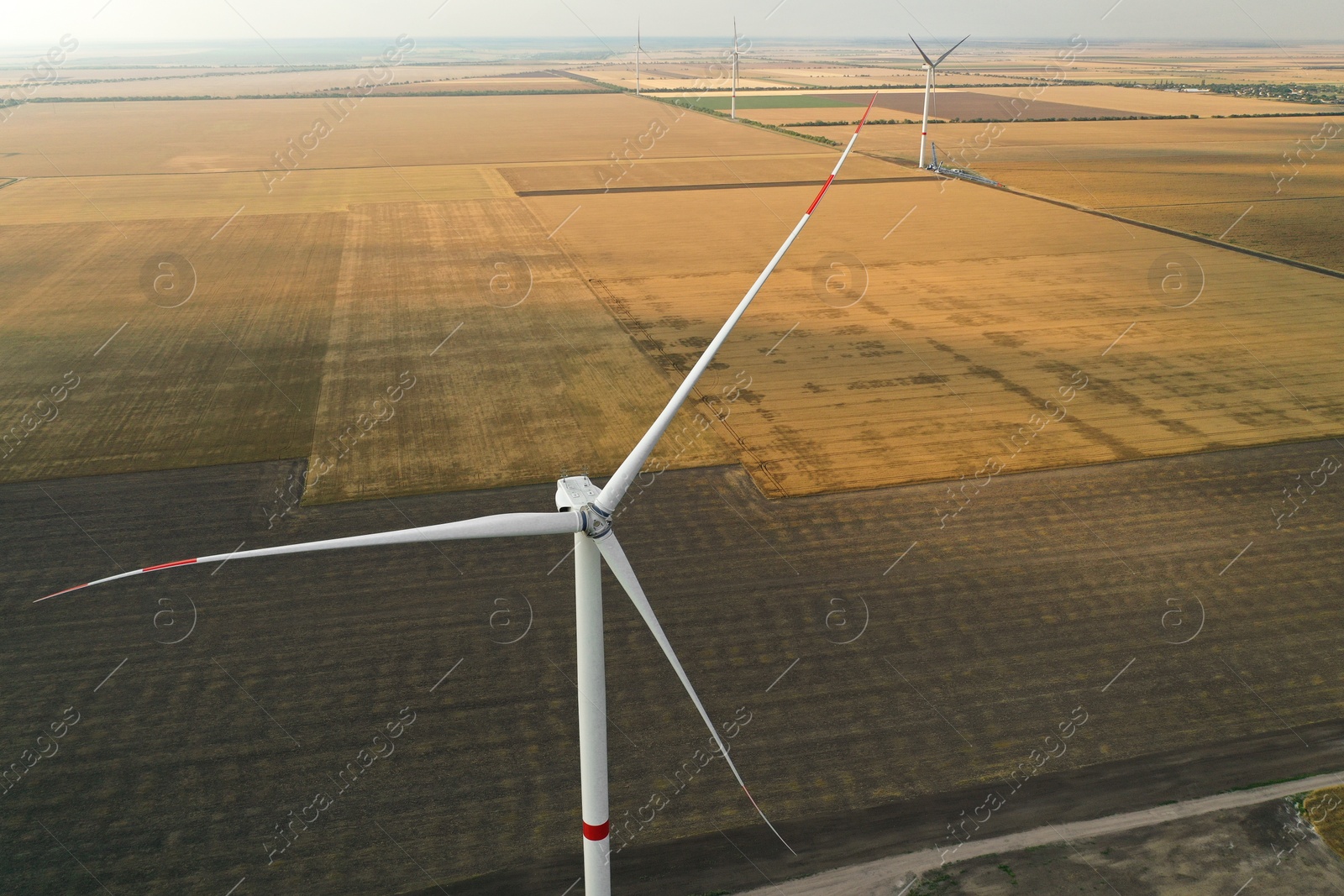 Photo of Modern windmill in field, space for text. Energy efficiency