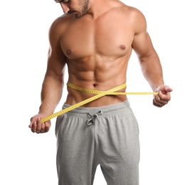 Photo of Young man with slim body using measuring tape on white background, closeup view