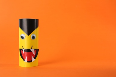 Funny yellow monster on orange background, space for text. Halloween decoration