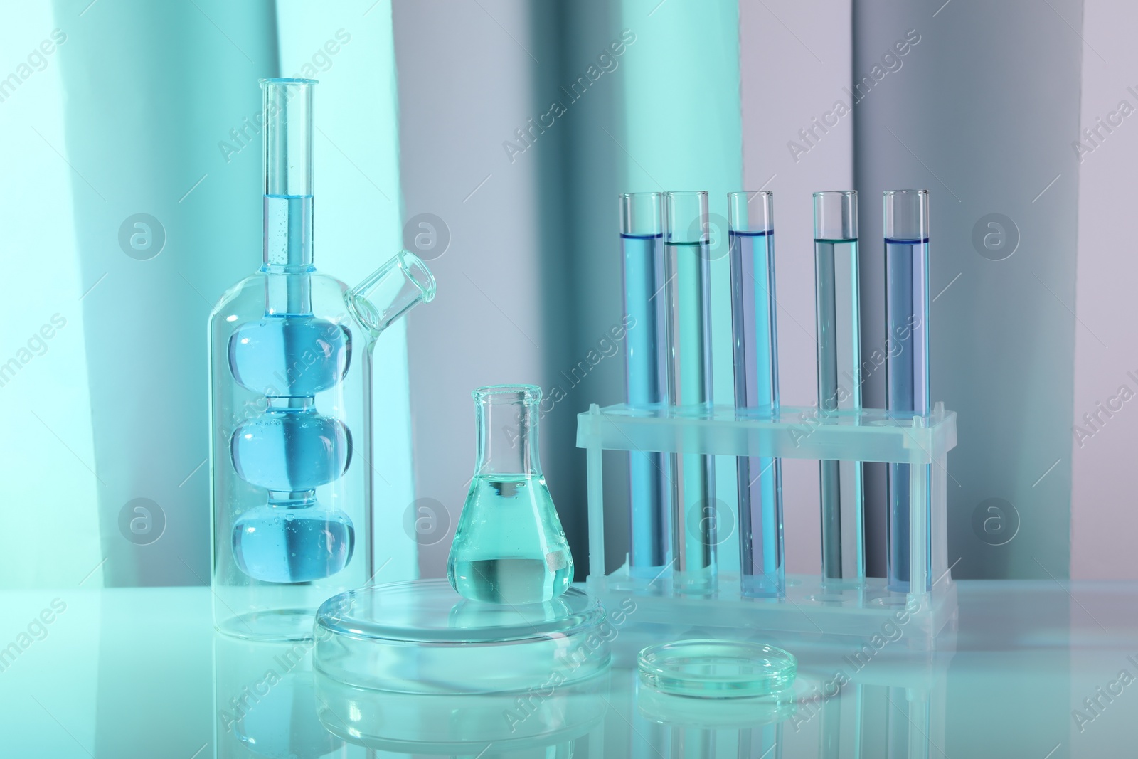 Photo of Laboratory analysis. Different glassware on table against color background