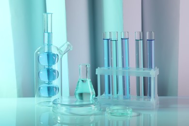 Laboratory analysis. Different glassware on table against color background