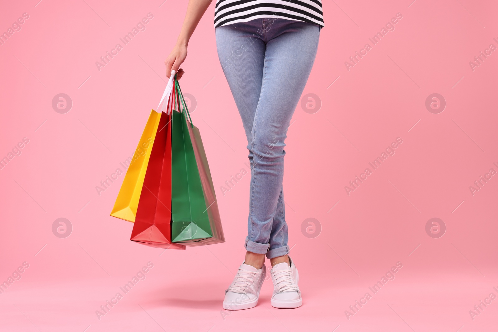 Photo of Woman with shopping bags on pink background, closeup