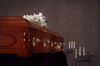 Photo of Wooden casket with white lilies in funeral home