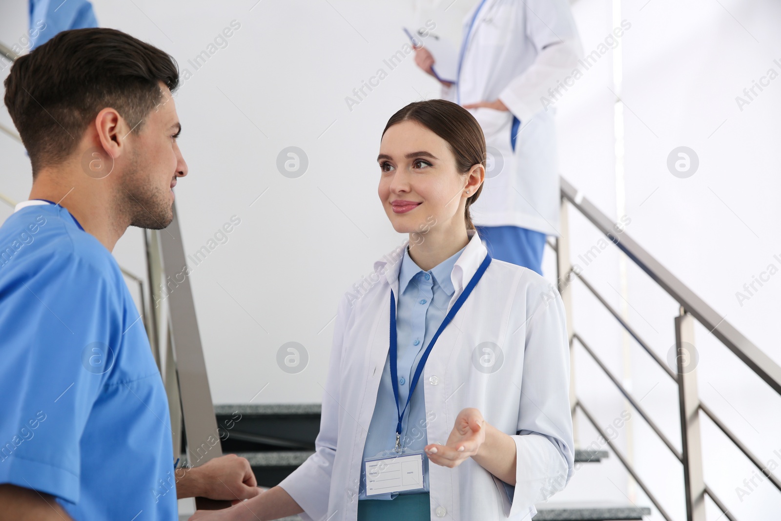 Photo of Female doctor talking to colleague on staircase in clinic