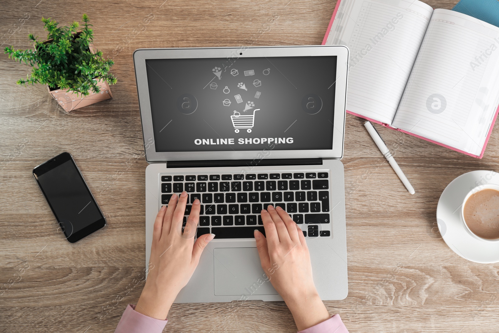 Image of Woman using laptop for online shopping at wooden table, top view