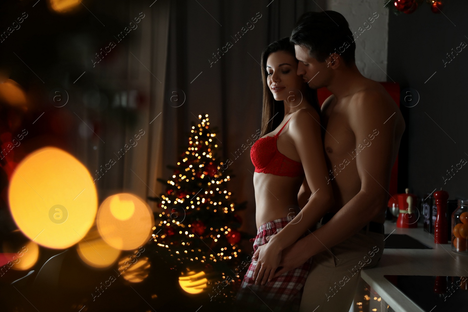 Photo of Passionate young couple enjoying each other in kitchen. Christmas celebration