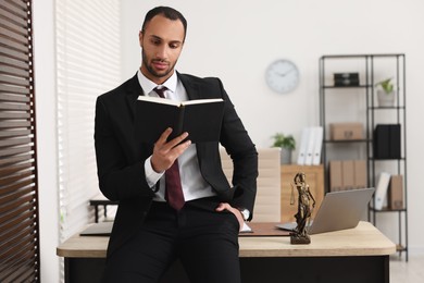 Serious lawyer reading book in office, space for text