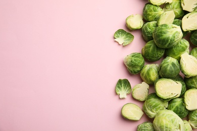 Photo of Fresh Brussels sprouts on pink background, flat lay. Space for text