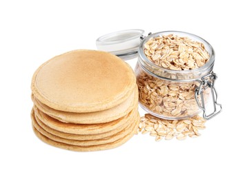 Photo of Tasty oatmeal pancakes and flakes on white background