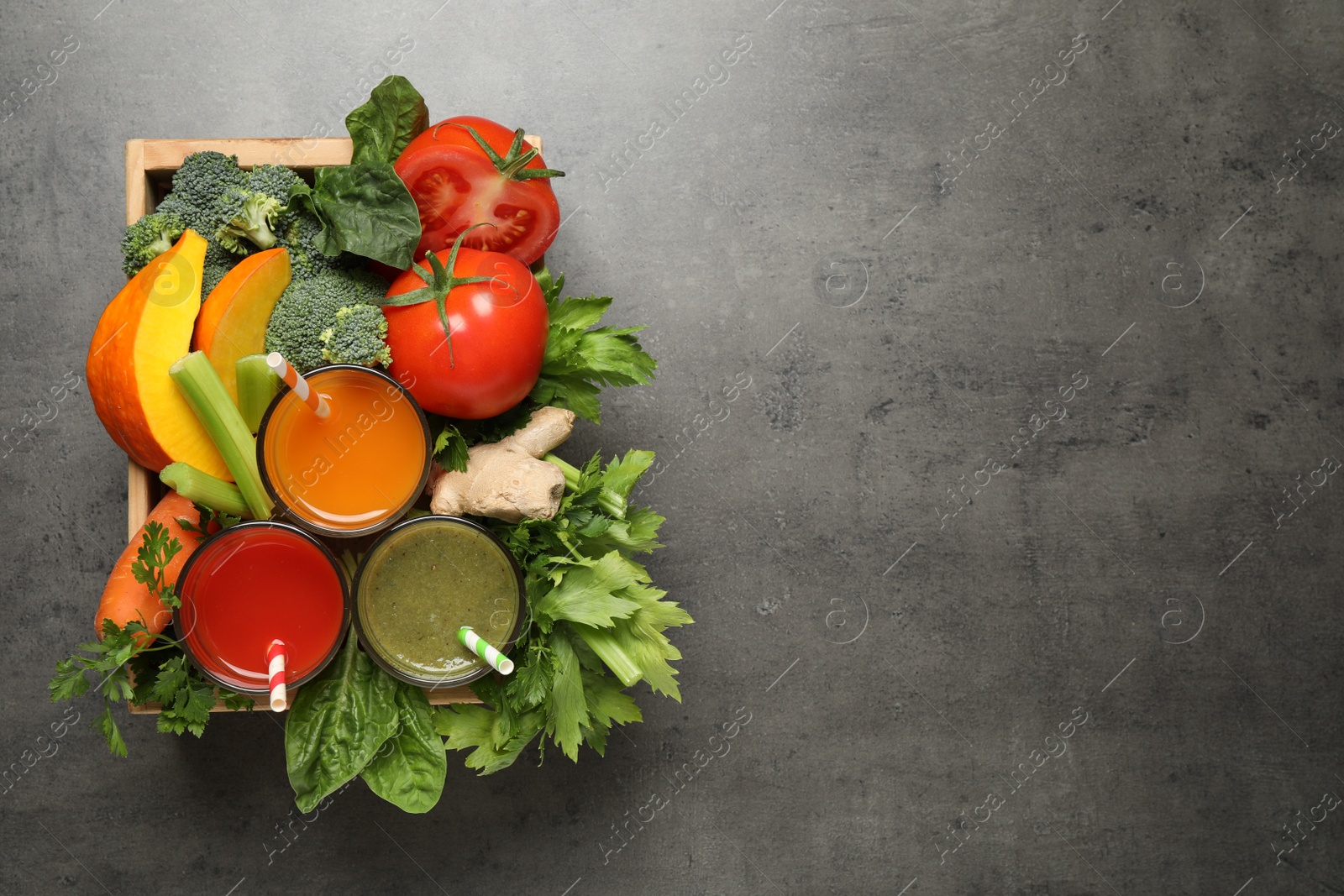 Photo of Delicious vegetable juices and fresh ingredients on grey table, top view. Space for text