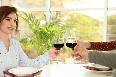 People with glasses of wine at table in restaurant